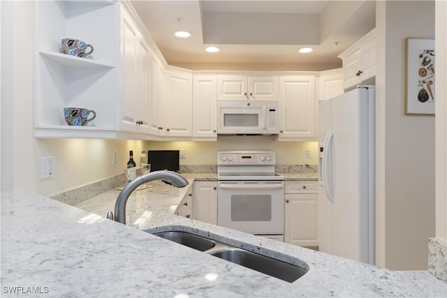 kitchen with white cabinetry, white appliances, light stone countertops, and recessed lighting