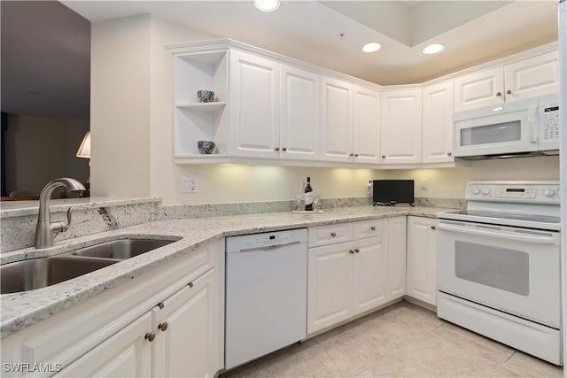 kitchen with light tile patterned floors, a sink, white appliances, recessed lighting, and white cabinetry