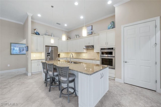 9282 Quarry Dr, Naples, FL 34120 - kitchen featuring ornamental molding, white cabinets, under cabinet range hood, stainless steel appliances, and a sink