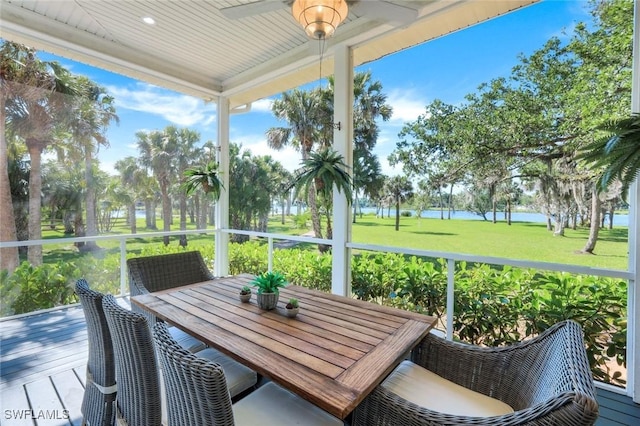 sunroom / solarium with outdoor dining area, a water view, and ceiling fan