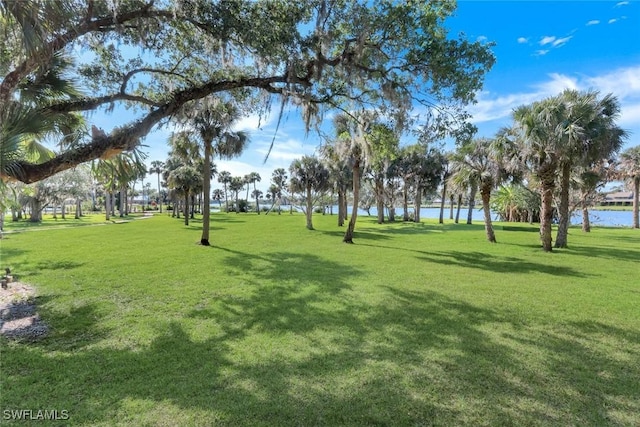 view of home's community featuring a lawn and a water view