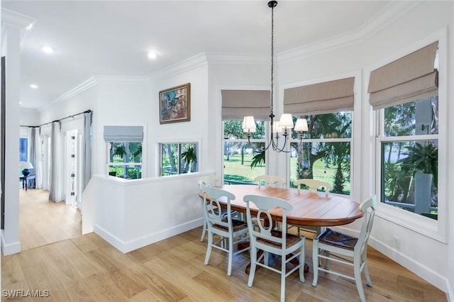 dining area with a wealth of natural light, baseboards, an inviting chandelier, and ornamental molding