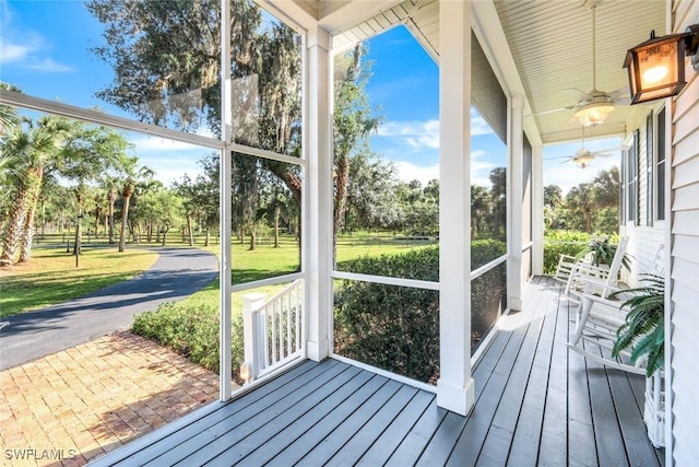 unfurnished sunroom featuring a ceiling fan and a healthy amount of sunlight