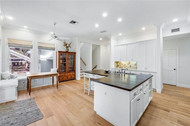 kitchen featuring recessed lighting, dark countertops, visible vents, a sink, and tasteful backsplash