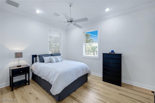 bedroom with crown molding, visible vents, and light wood-type flooring