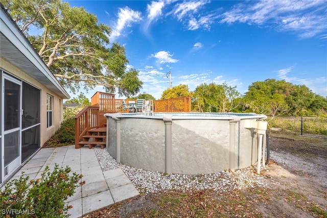 view of patio with a fenced in pool, fence, and a wooden deck