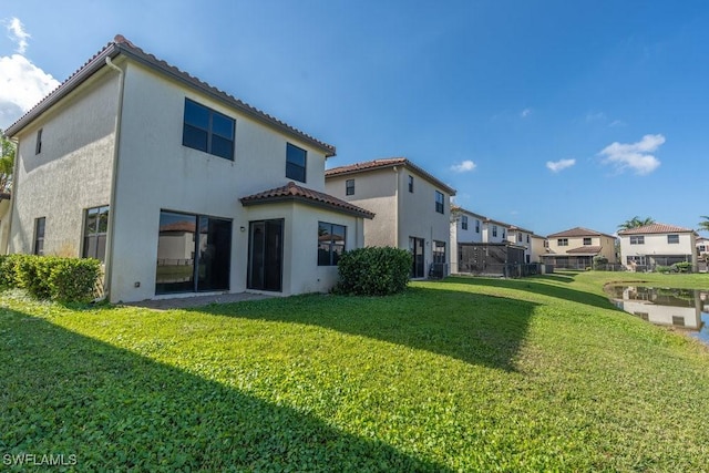 5467 Ferris Ave, Ave Maria, FL 34142 - back of house featuring a lawn, stucco siding, a tile roof, and a residential view