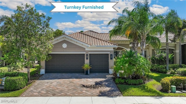 4194 Aspen Chase Dr, Naples, FL 34119 - mediterranean / spanish house featuring a garage, decorative driveway, stucco siding, and a tile roof