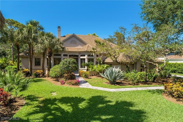 3370 Oaklake Ct, Bonita Springs, FL 34134 - view of front facade featuring stucco siding, a tiled roof, a chimney, and a front lawn