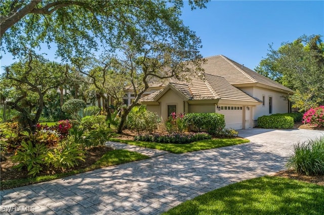 3370 Oaklake Ct, Bonita Springs, FL 34134 - view of front facade featuring a tiled roof, a garage, stucco siding, and decorative driveway