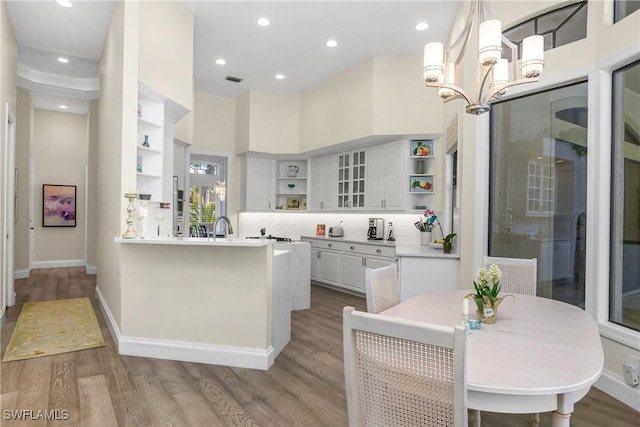 3370 Oaklake Ct, Bonita Springs, FL 34134 - kitchen with an inviting chandelier, a peninsula, open shelves, white cabinets, and wood finished floors