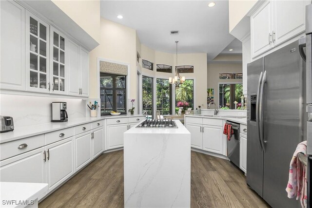 3370 Oaklake Ct, Bonita Springs, FL 34134 - kitchen with dark wood-style flooring, white cabinets, appliances with stainless steel finishes, and a notable chandelier