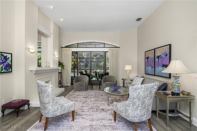3370 Oaklake Ct, Bonita Springs, FL 34134 - living area featuring visible vents, baseboards, a fireplace with raised hearth, and wood finished floors