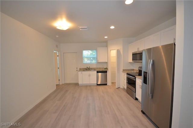 3341 Willard St, Fort Myers, FL 33916 - kitchen with a sink, light wood finished floors, white cabinetry, appliances with stainless steel finishes, and visible vents