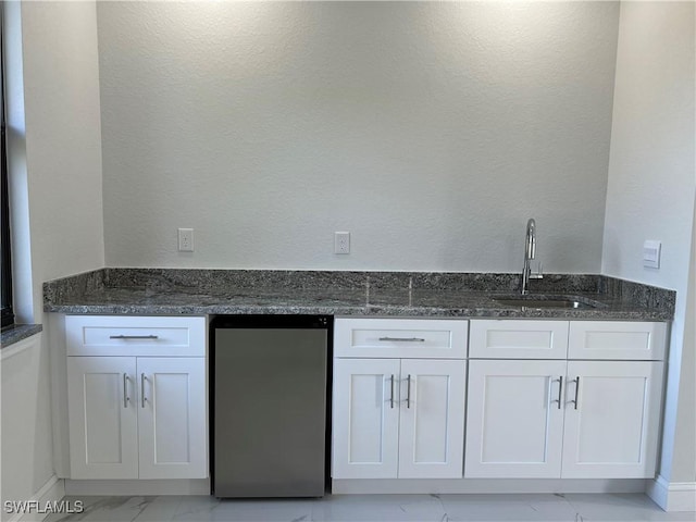bar featuring a sink, indoor wet bar, fridge, and marble finish floor