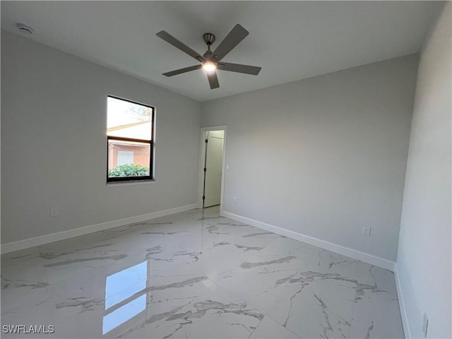 unfurnished room featuring baseboards, ceiling fan, and marble finish floor