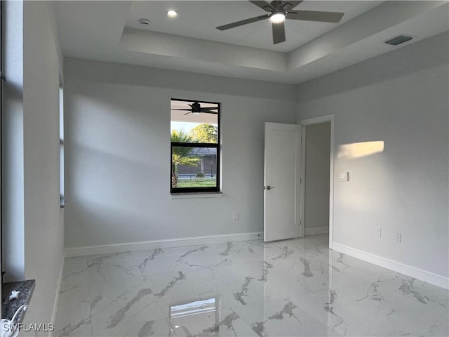 spare room featuring a ceiling fan, baseboards, and visible vents