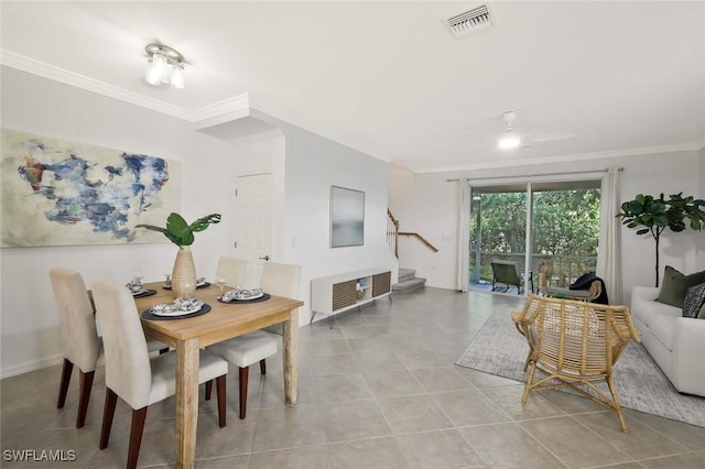tiled dining area featuring stairs, visible vents, ornamental molding, and a ceiling fan