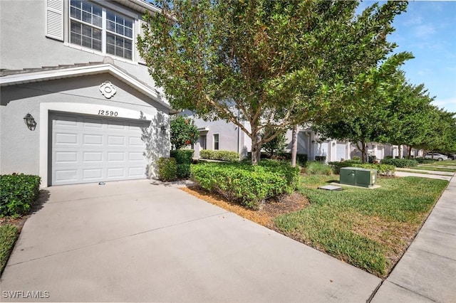 view of side of property with stucco siding, an attached garage, and concrete driveway