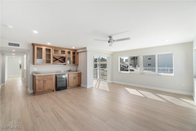 25900 Hickory Blvd Unit 101, Bonita Springs, FL 34134 - interior space featuring brown cabinets, light wood-style floors, glass insert cabinets, wine cooler, and visible vents