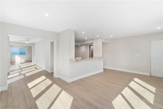25900 Hickory Blvd Unit 101, Bonita Springs, FL 34134 - unfurnished living room with baseboards, a sink, light wood finished floors, and recessed lighting
