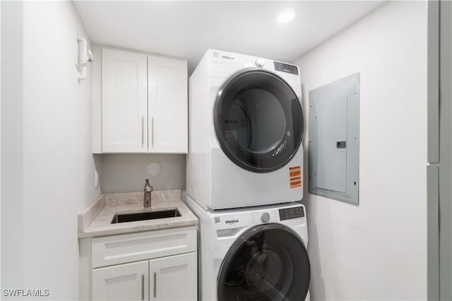 25900 Hickory Blvd Unit 101, Bonita Springs, FL 34134 - clothes washing area with cabinet space, stacked washing maching and dryer, electric panel, and a sink