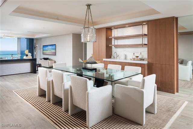 6897 Grenadier Blvd Unit 1602, Naples, FL 34108 - dining room with a raised ceiling, light wood-style floors, and indoor wet bar
