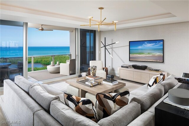 6897 Grenadier Blvd Unit 1602, Naples, FL 34108 - living room featuring ceiling fan with notable chandelier and a raised ceiling