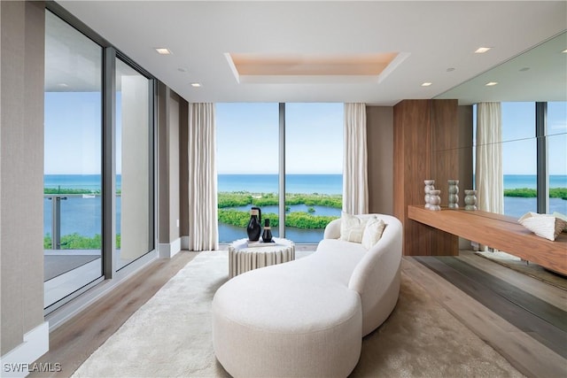6897 Grenadier Blvd Unit 1602, Naples, FL 34108 - interior space with a water view, a tray ceiling, a wall of windows, and wood finished floors