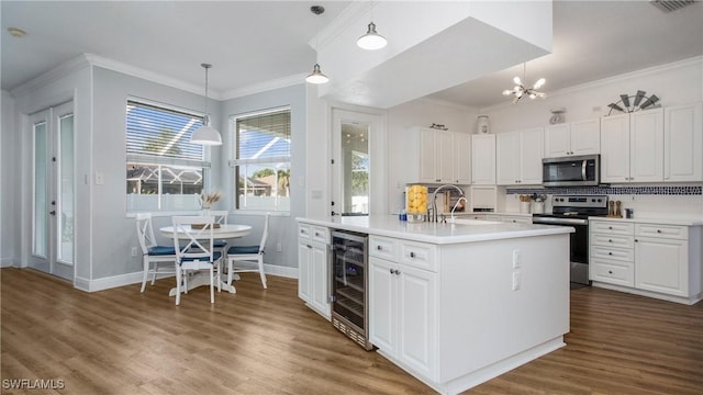 1824 SE 20th Ln, Cape Coral, FL 33990 - kitchen featuring a sink, stainless steel appliances, wood finished floors, beverage cooler, and baseboards