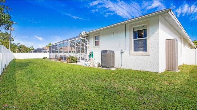 1824 SE 20th Ln, Cape Coral, FL 33990 - rear view of property featuring a yard, glass enclosure, stucco siding, and a fenced backyard