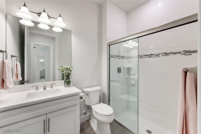 full bath with vanity, a shower stall, and toilet