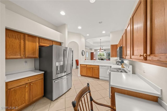6683 Castlelawn Pl, Naples, FL 34113 - kitchen with stainless steel appliances, a peninsula, brown cabinets, and light countertops