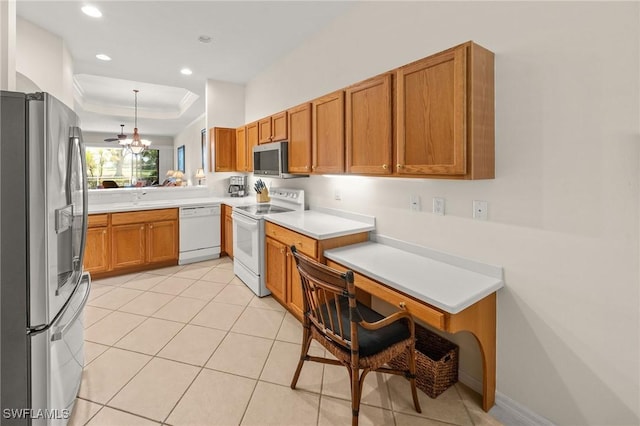 6683 Castlelawn Pl, Naples, FL 34113 - kitchen with stainless steel appliances, brown cabinets, a tray ceiling, and a sink