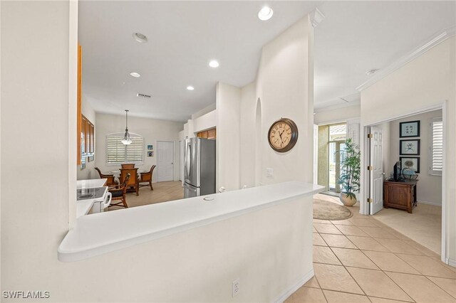 6683 Castlelawn Pl, Naples, FL 34113 - kitchen featuring light tile patterned floors, decorative light fixtures, freestanding refrigerator, crown molding, and recessed lighting