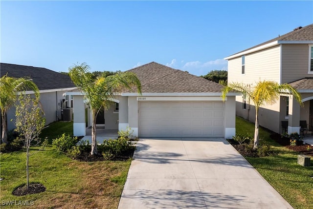 20160 Caroline Creek Pl, Lehigh Acres, FL 33974 - view of front of home with a garage, driveway, a front yard, stucco siding, and roof with shingles