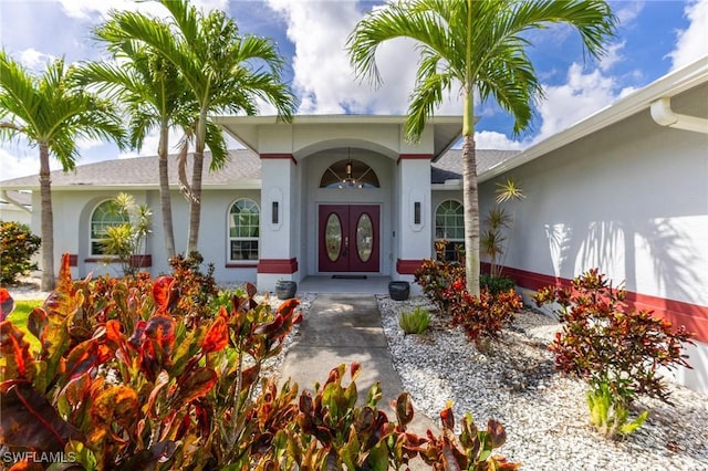 view of exterior entry with stucco siding and french doors