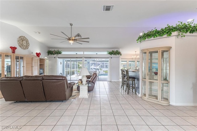 living area with vaulted ceiling, baseboards, light tile patterned flooring, visible vents, and a ceiling fan