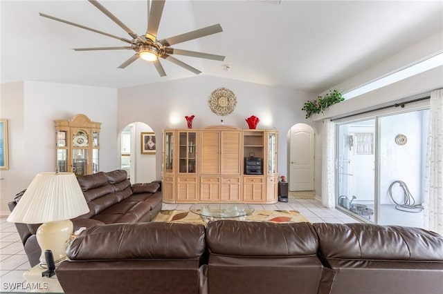 living room with vaulted ceiling, arched walkways, ceiling fan, and light tile patterned floors