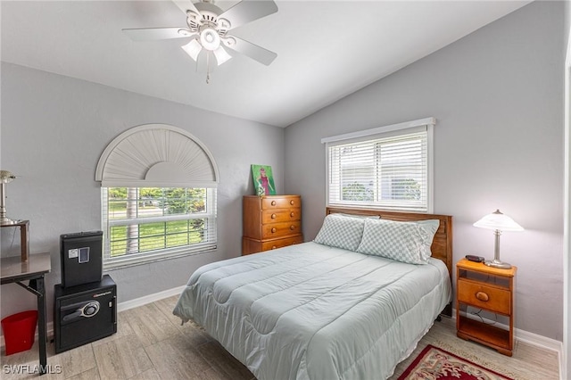 bedroom with baseboards, multiple windows, lofted ceiling, and wood finished floors