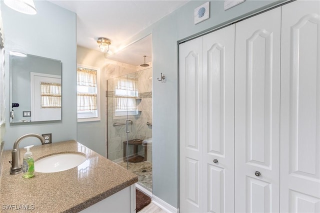 full bath with a closet, a stall shower, and vanity
