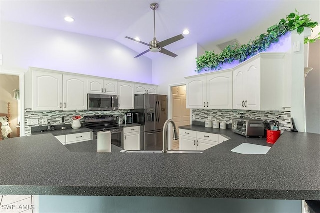 kitchen featuring stainless steel appliances, a toaster, dark countertops, a ceiling fan, and a peninsula