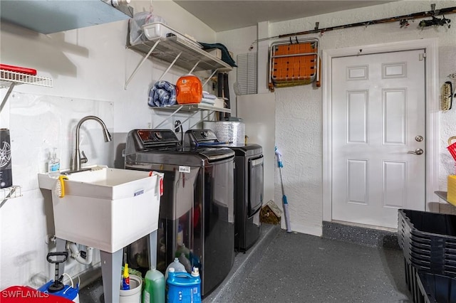 clothes washing area with a sink, washer and clothes dryer, and laundry area