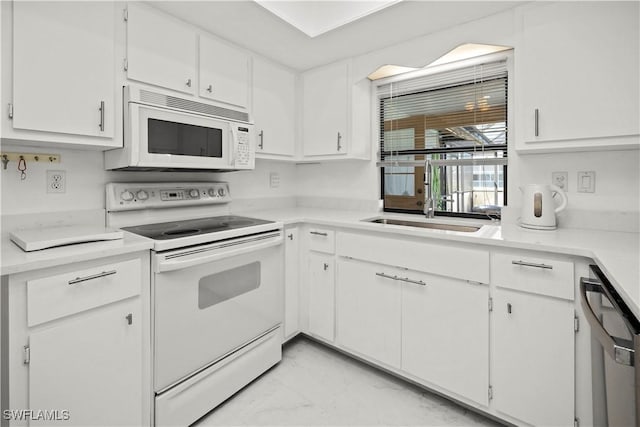 kitchen featuring a sink, light countertops, white appliances, white cabinetry, and marble finish floor