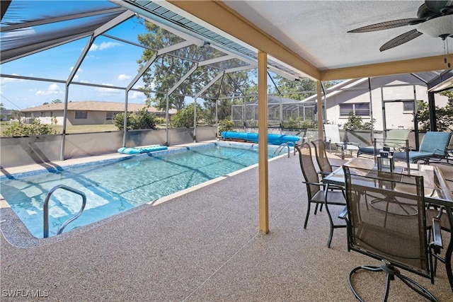 outdoor pool with a patio area, ceiling fan, and glass enclosure