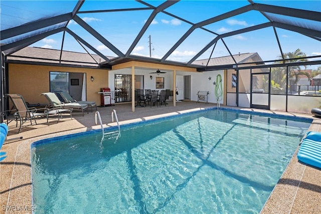 pool with a lanai, a patio area, and a ceiling fan