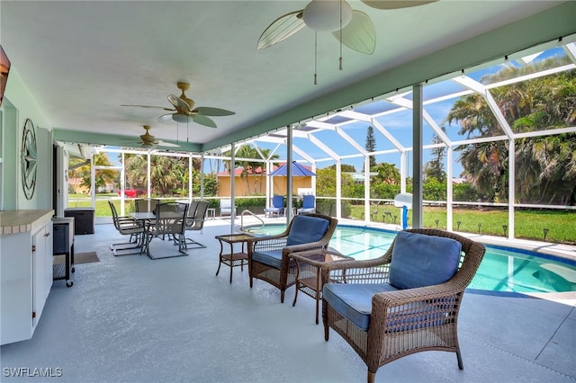 outdoor pool featuring a patio area, ceiling fan, and glass enclosure