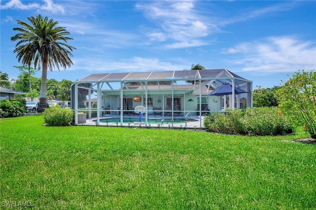 back of property featuring an outdoor pool, a lawn, and a lanai
