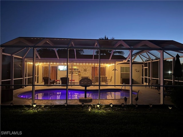 back of house with a patio, an outdoor pool, and a lanai