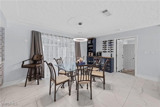 3586 Croton Rd, Naples, FL 34104 - dining space with marble finish floor, baseboards, visible vents, and a textured ceiling